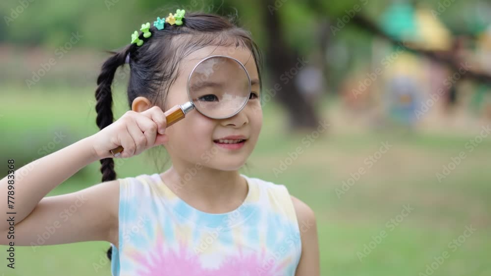 Portrait of asian little girl exploring the nature with magnifying ...