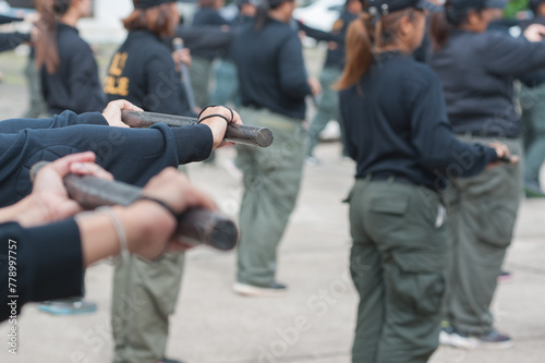 Female riot police practice using batons to control crowds. 