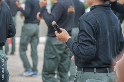 Female riot police practice using batons to control crowds. 