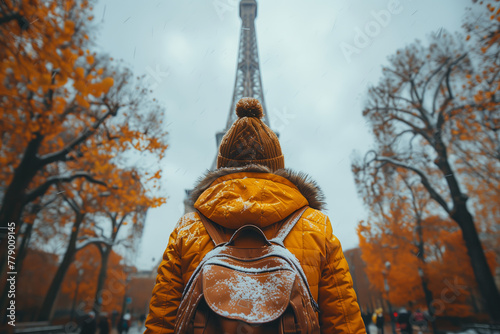 Traveler facing Eiffel Tower on a rainy day