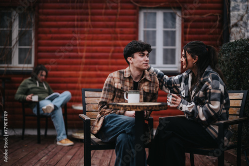 A young and affectionate couple sharing a warm moment over coffee on their home s outdoor patio with a relaxed ambiance.
