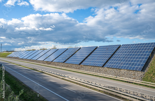  Solar panels on highway wall of autobahn with blue sky and clouds