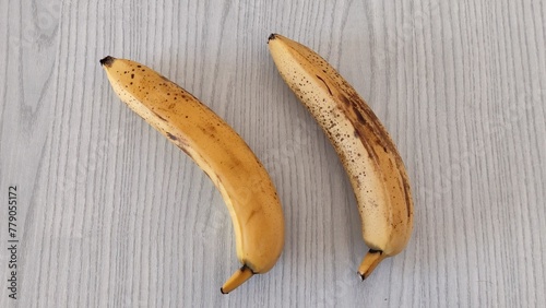 Two bananas lie on the wooden table