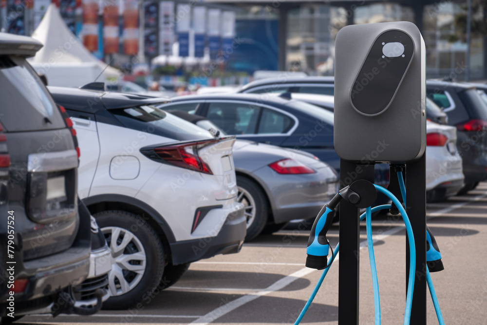 Electric vehicles charging station on a background of a row of cars. Concept. Electric vehicles charging station on a background of a row of cars. Concept.