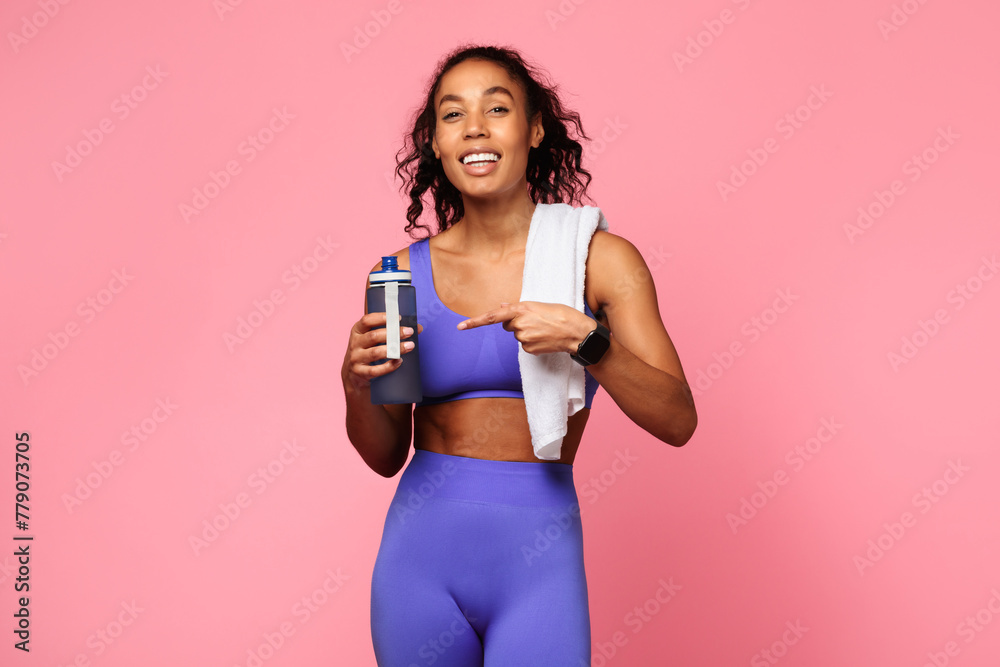 Active woman with a towel pointing at bottle Active woman with a towel pointing at bottle