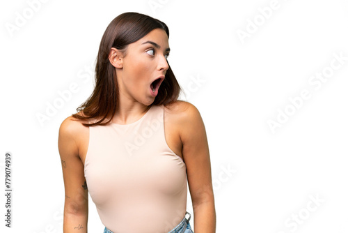 Young caucasian woman isolated on green chroma background doing surprise gesture while looking to the side