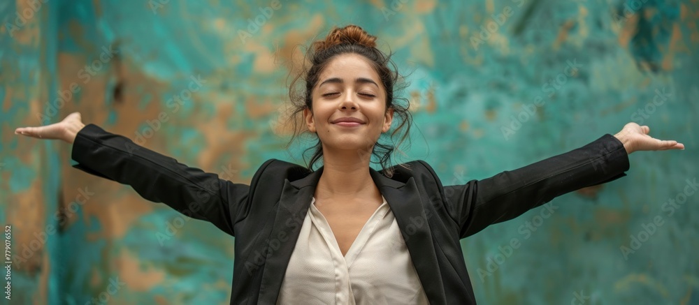 A cheerful young Hispanic woman in business attire standing confidently in front of a rusty wall. A cheerful young Hispanic woman in business attire standing confidently in front of a rusty wall.