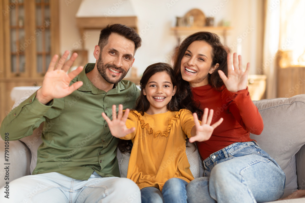 Family happily waving at the camera at home Family happily waving at the camera at home