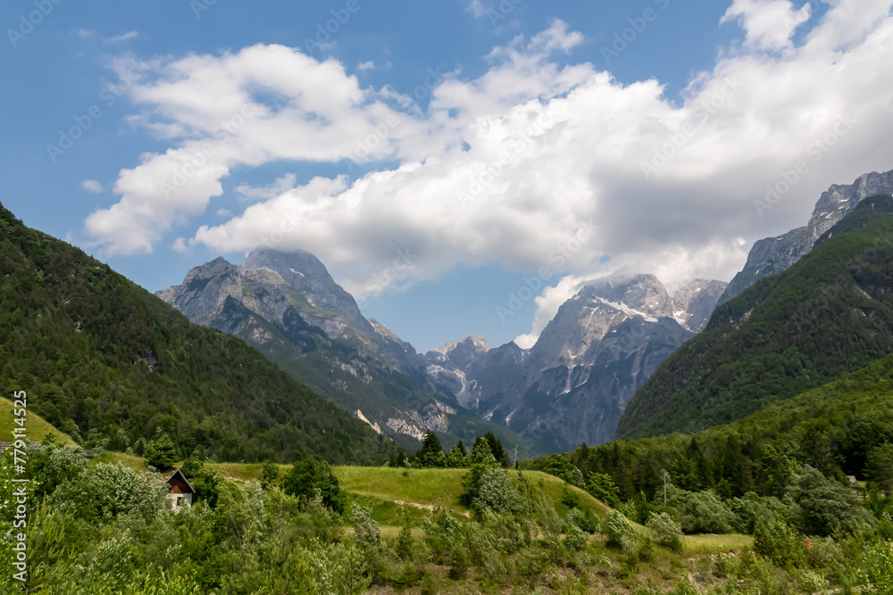 Scenic view of mount Mangart and Jalovec in Log pod Mangartom in Julian Alps, Slovenia. Jagged contours of majestic mountain peaks in serene Soca valley. Wanderlust in untamed Slovenian Alps. Hiking