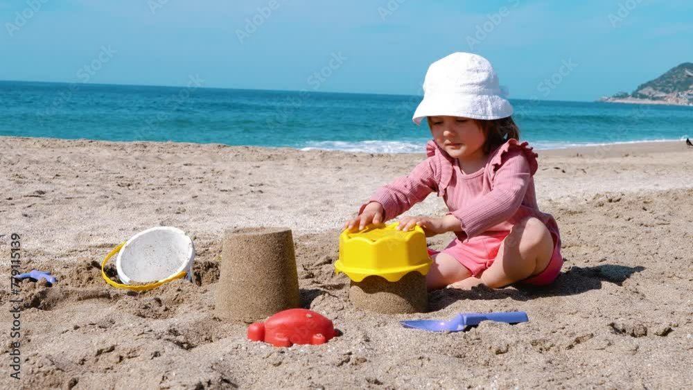 A child plays with sand on the beach. Develop children. Life by the sea A child plays with sand on the beach. Develop children. Life by the sea