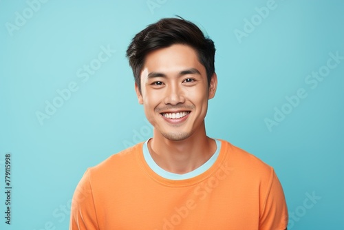 A man with a bright orange shirt is smiling at the camera