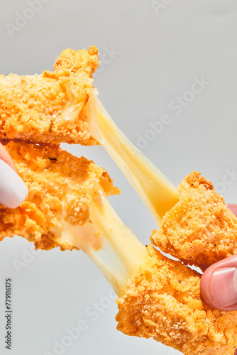 Crispy cheese fried breaded mozzarella cheese sticks stretch two hands