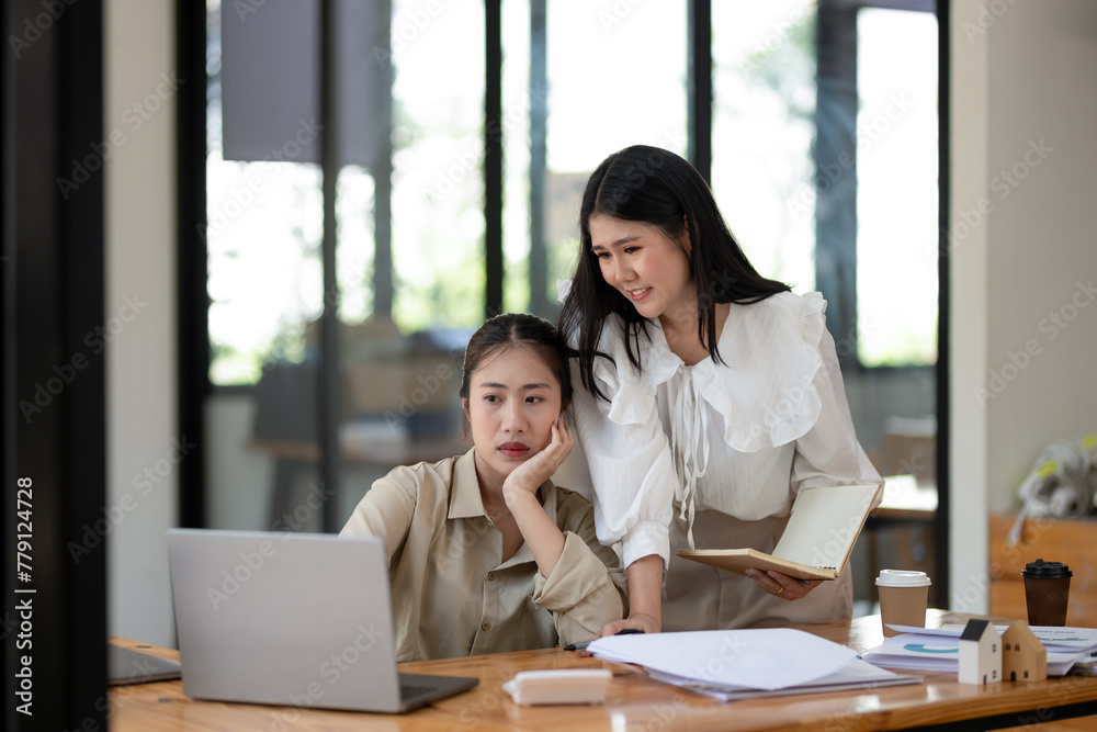 Two female colleagues discuss and review documents together in a bright office, working collaboratively on a business project. Two female colleagues discuss and review documents together in a bright office, working collaboratively on a business project.