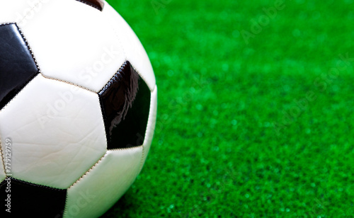 Classic soccer ball on artificial green grass