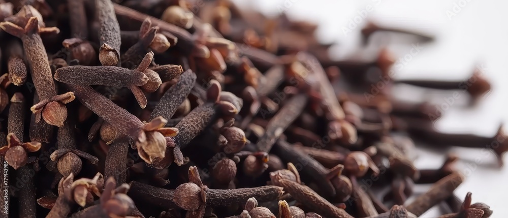 A large cluster of cloves arranged neatly atop a pristine white surface A large cluster of cloves arranged neatly atop a pristine white surface