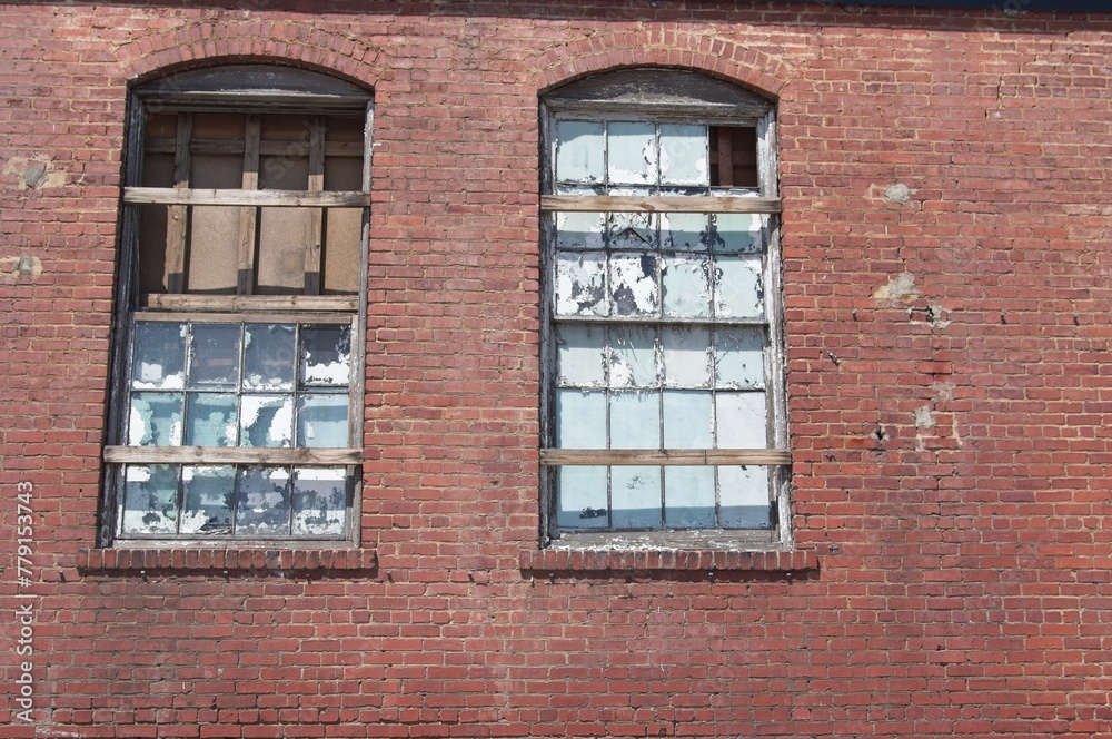 Abandoned brick industrial building with broken and weather worn windows