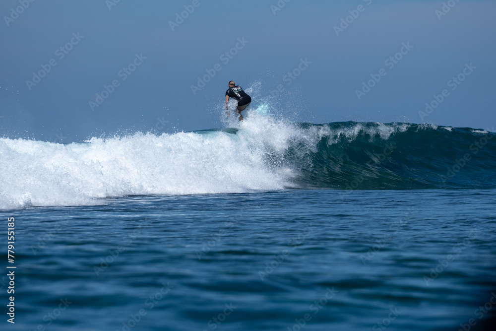 Surfers enjoy a sunny day and ride the big waves Surfers enjoy a sunny day and ride the big waves