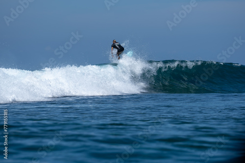 Surfers enjoy a sunny day and ride the big waves