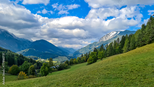 Lush green alpine meadows and forest with scenic view of Karawanks mountain range in Carinthia, Austria. Remote villages on alpine landscape in Bodental, Austrian Alps. Wanderlust concept in spring photo
