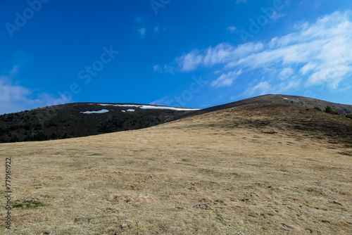 Panoramic view of golden grassy hills of Peterer Riegel on Packalpe, Lavanttal Alps in Styria, Austria. Remote mountain landscape in Austrian Alps. Wanderlust. Tranquil serene scene on alpine meadows photo