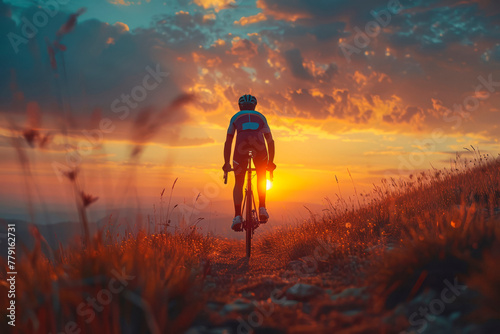 Silhouette of a cyclist on a gravel bike riding on a gravel trail at sunset.