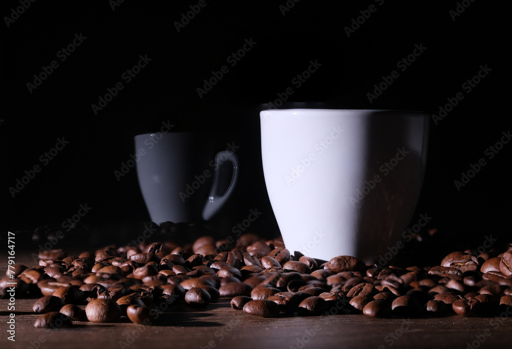 Fototapeta premium Tazzina di caffè tra i chicchi di caffè sul tavolo, riflesso sul vetro della tazzina