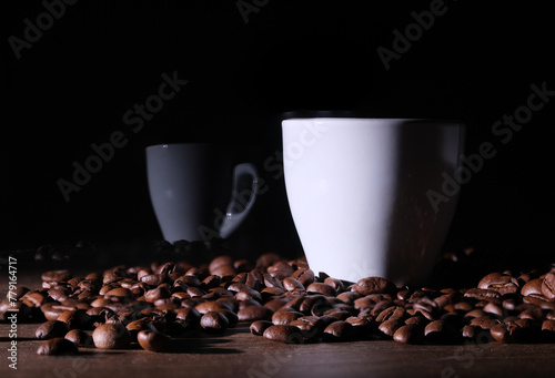 Tazzina di caffè tra i chicchi di caffè sul tavolo, riflesso sul vetro della tazzina photo