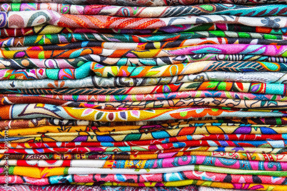 Stacked assortment of colorful fabric for sale