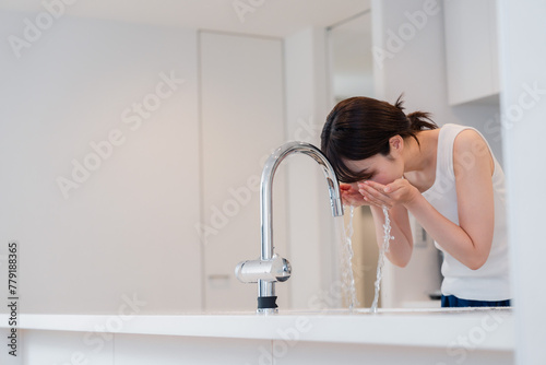 家で洗顔をする若い女性 photo