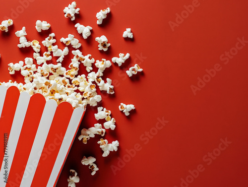 scattered popcorn and popcorn in a box, red background