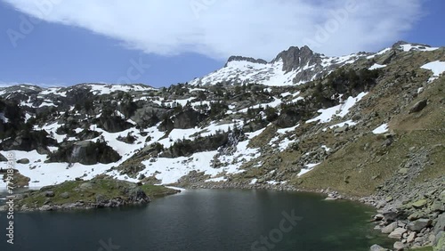 Pico de alta montaña y lago alimentado con agua en primavera. Lago Major de Colomers. Pirineos, Vall d'Aran, Cataluña, España. photo