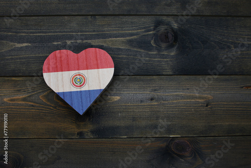 wooden heart with national flag of paraguay on the wooden background.