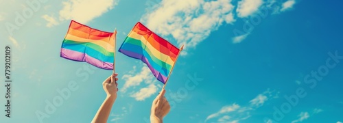 A pair of vibrant pride flags wave against the backdrop of a bright blue sky, a visual representation of freedom and the enduring spirit of the LGBTQ+ community.