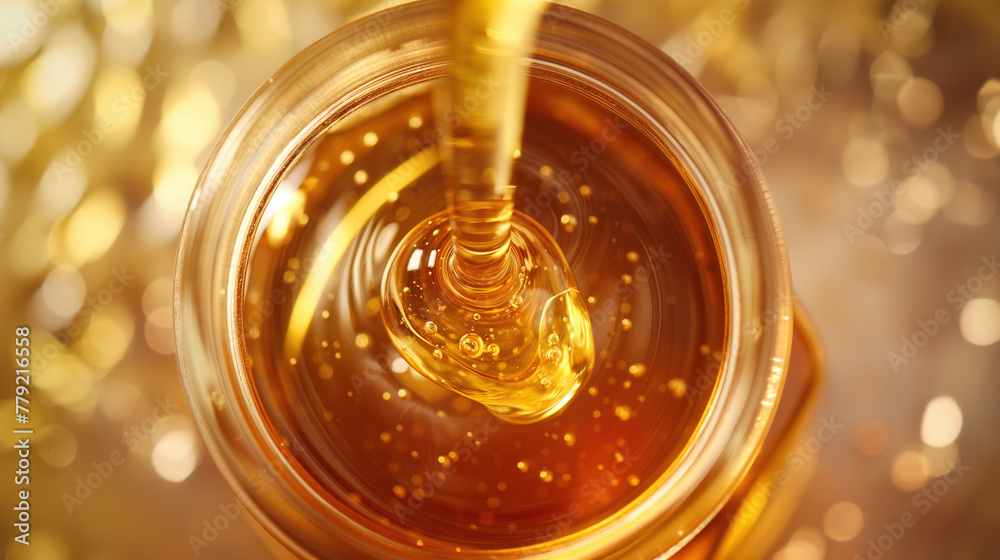  Close up of honey pouring into a jar, top view, gold background