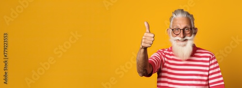 Old senior man thumb up yellow background photo