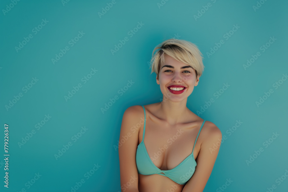 Beautiful woman in a bikini posing in front of a blue background. Summer vipe. Beautiful woman in a bikini posing in front of a blue background. Summer vipe.