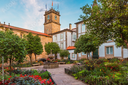 Small square in Santiago de Compostela city with flower garden and fountain, Galicia, Spain. Popular touristic landmark