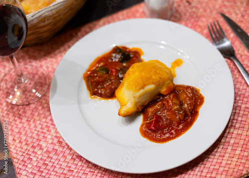 Delicious stewed cod served with samfaina vegetables served in restaurant photo