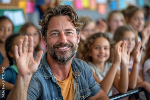 An engaging male teacher in a denim jacket extends a friendly greeting amidst a diverse group of smiling students