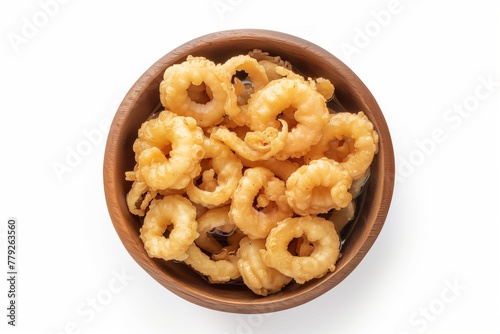A top-down view of golden-brown fried calamari rings, generously portioned in a white ceramic bowl, presented on a clean white background.