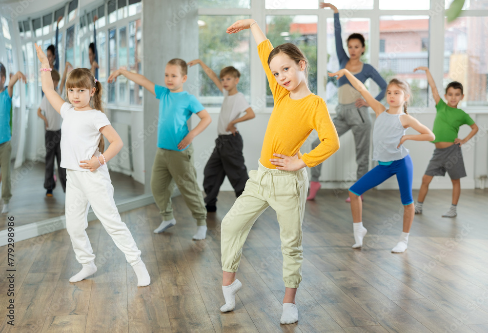 Group of boys and girls rehearsing modern dance in studio