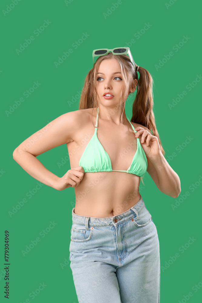 Beautiful young woman in stylish outfit on green background - obrazy, fototapety, plakaty 