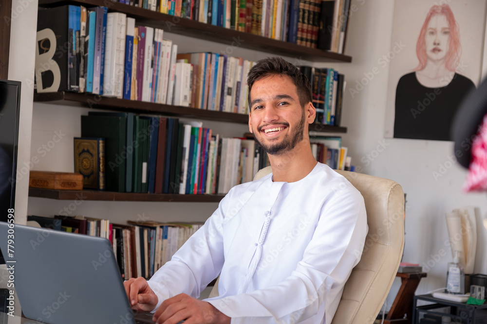 confident arabic male working on his laptop with modern background and library confident arabic male working on his laptop with modern background and library