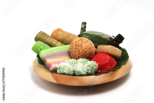 Various kinds of Jajan Pasar, traditional Indonesian market snacks, on the wooden plate with banana leaves isolated on white background clipping path photo