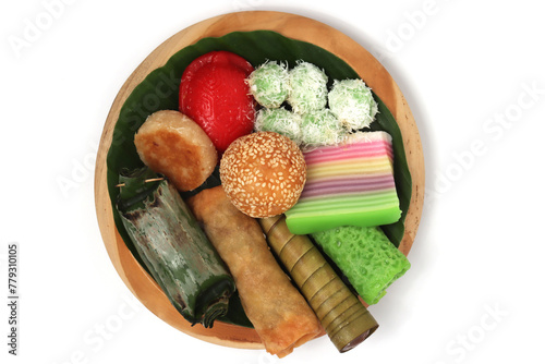 Various kinds of Jajan Pasar, traditional Indonesian market snacks, on the wooden plate with banana leaves top view isolated on white background clipping path