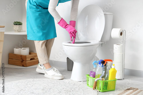 Woman cleaning toilet bowl in modern bathroom, closeup © Pixel-Shot
