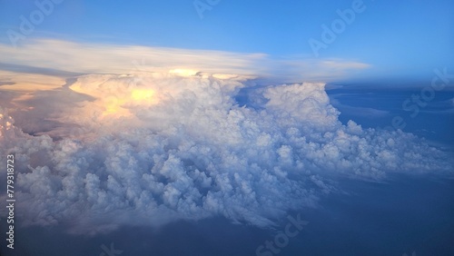 Flying above the blue sky clouds on sunset of airplane flight. View from the window of the plane in Vietnam domestic flight.