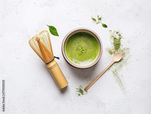 Minimalist composition of matcha tea next to a traditional whisk and bowl capturing the serene process of tea preparation