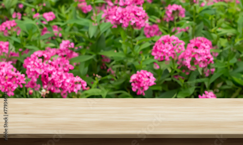 natural horizontal wood table background with flower garden behind