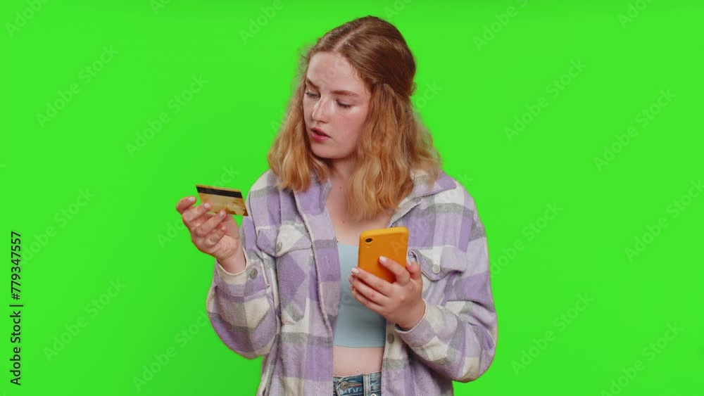 Happy caucasian woman using credit bank card and smartphone while transferring spending money, purchases online shopping, ordering food delivery. Redhead girl isolated on green chroma key background Happy caucasian woman using credit bank card and smartphone while transferring spending money, purchases online shopping, ordering food delivery. Redhead girl isolated on green chroma key background